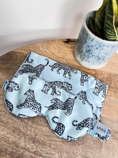 MYRN Blue silk eye mask and travel case next to a snake plant